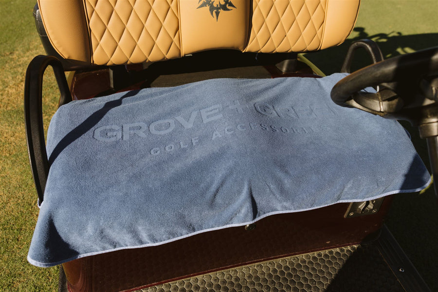 Grove + Green navy blue 100% terry cloth golf cart seat cover towel on a golf cart.