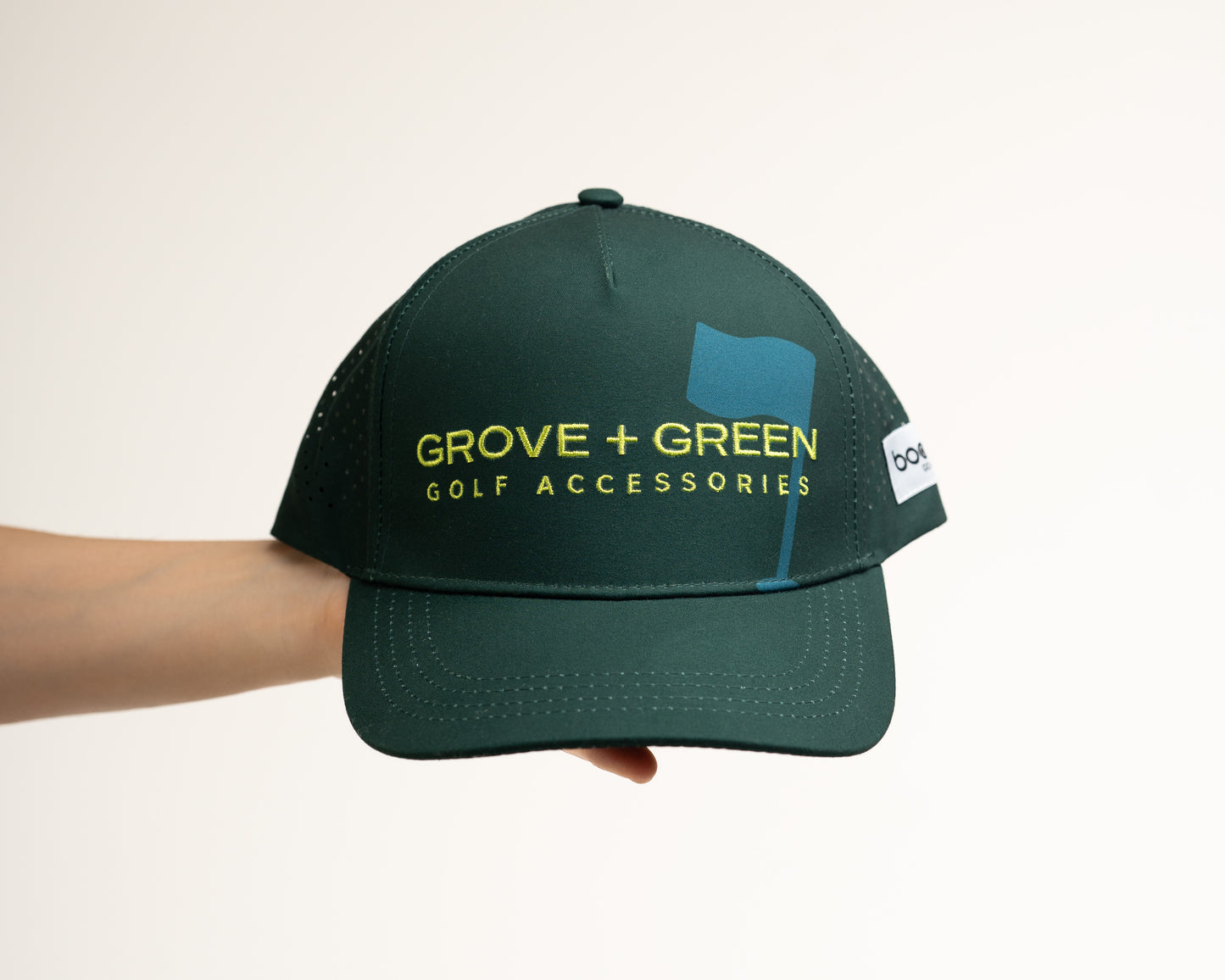 Front view of The Pursuit Hat in forest green featuring the embroidered Grove + Green logo and a classic curved brim.