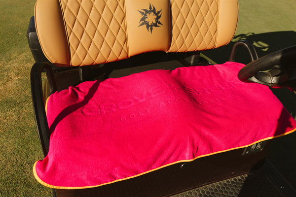 Grove + Green hot pink 100% terry cloth golf cart seat cover towel on a golf cart.