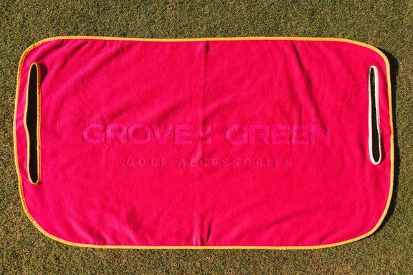 Grove + Green hot pink 100% terry cloth golf cart seat towel with orange trim.