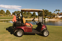 Burgundy golf cart with Grove + Green signature 100% terry cloth golf cart seat cover in orange coral.