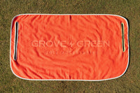 Grove + Green orange coral 100% terry cloth golf cart seat towel with light blue trim.