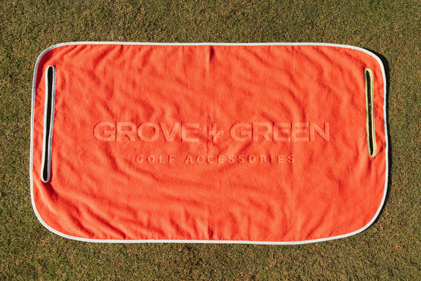 Grove + Green orange coral 100% terry cloth golf cart seat towel with light blue trim.