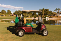 Burgundy golf cart with Grove + Green signature 100% terry cloth golf cart seat cover in golf green.